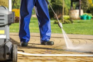 A man power washing a driveway